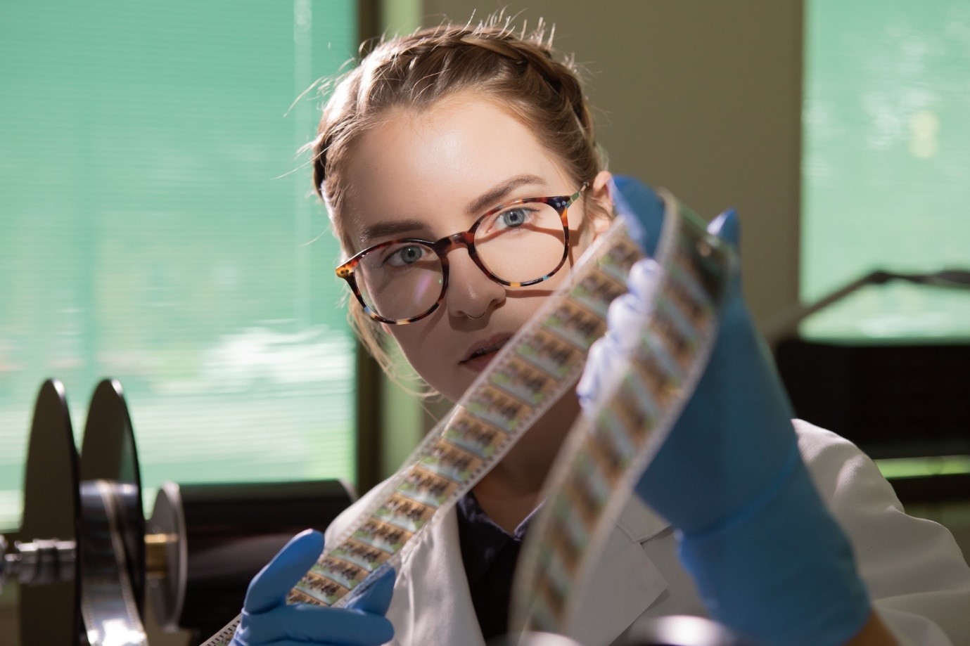 Young woman inspecting a strip of film.