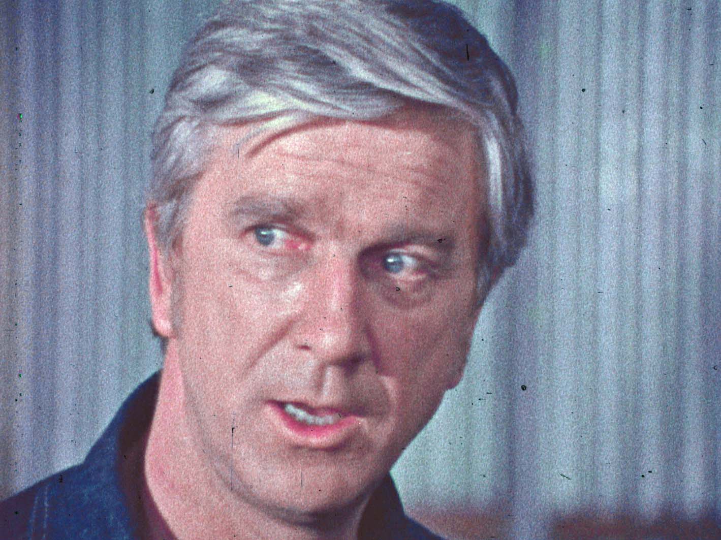 A close-up of Leslie Nielsen, looking away from the camera