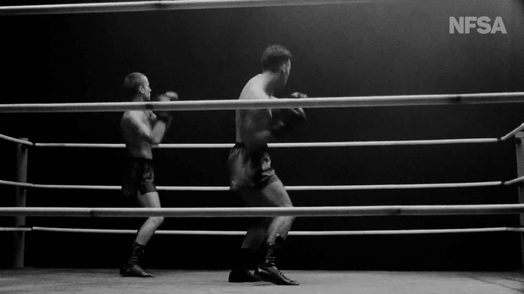 Two boxers in a boxing ring doing a dance routine