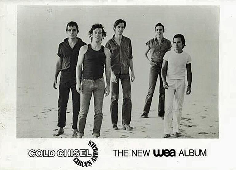 Band members of Cold Chisel, from left to right: Ian Moss, Jimmy Barnes, Don Walker, Steve Prestwich, Phil Small, standing facing towards camera against the background of Lake Eyre's salt pans.