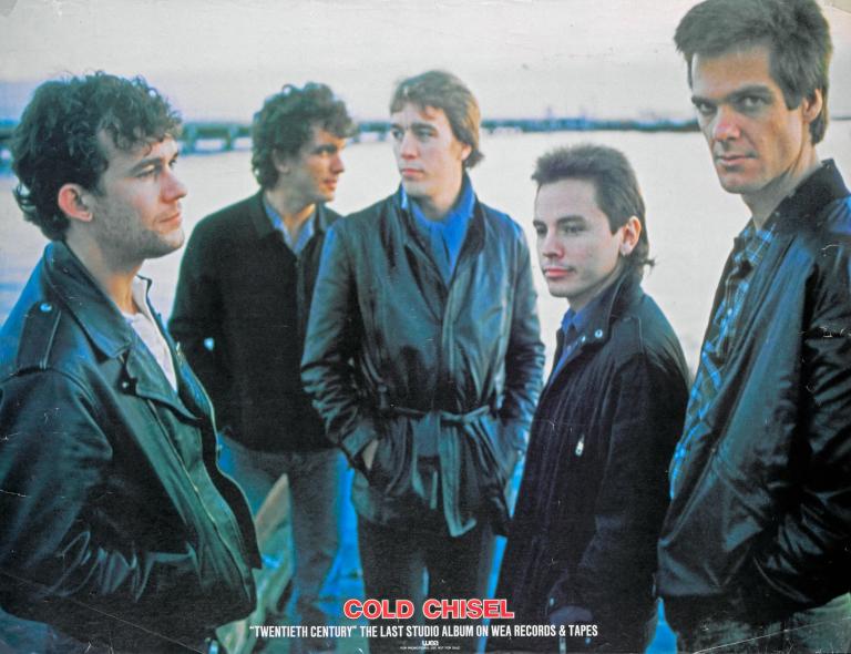 Five band members of Cold Chisel, from left to right Jimmy Barnes, Ian Moss, Steve Prestwich, Phil Small, Don Walker on a poster. The bottom reads 'Cold Chisel. "Twentieth Century" The last studio album on WEA records and tapes.