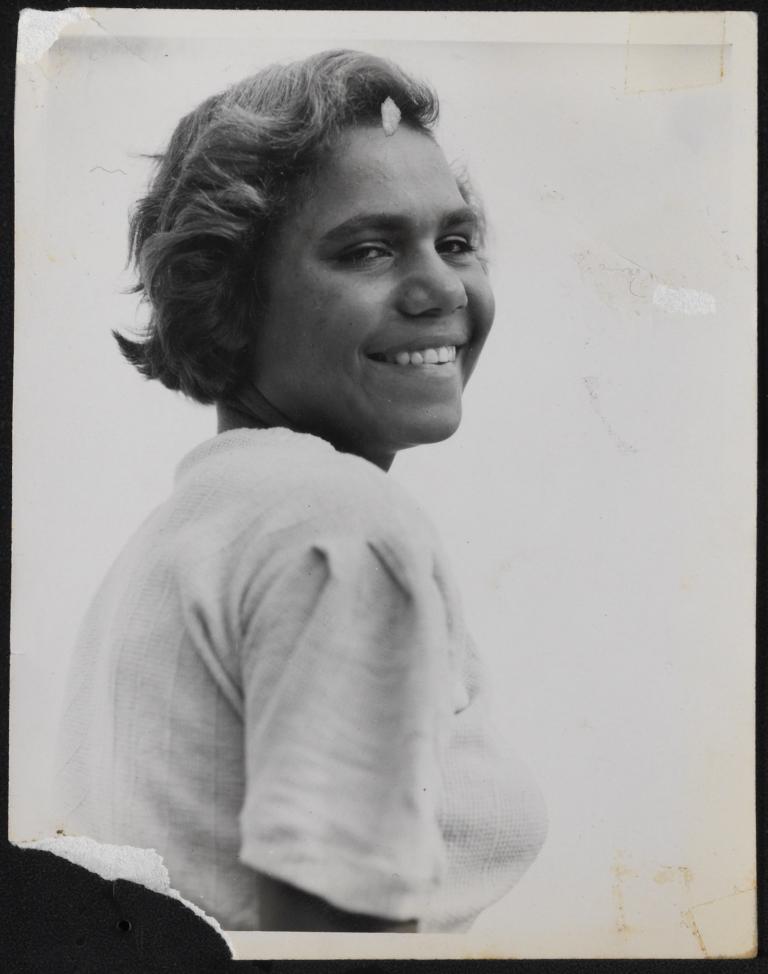 Actress Ngarla Kunoth in a still from the film Jedda. She is pictured from the waist up and looking back over her right shoulder and smiling.