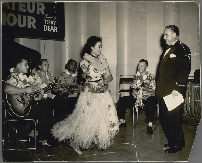 Still image from the radio program Australia's Amateur Hour. From right: Terry Dear, Tex Foote, Tifori Peni, Rodney Kindness, an unidentified man and a female dancer. All but Terry Dear are in Polynesian dress.