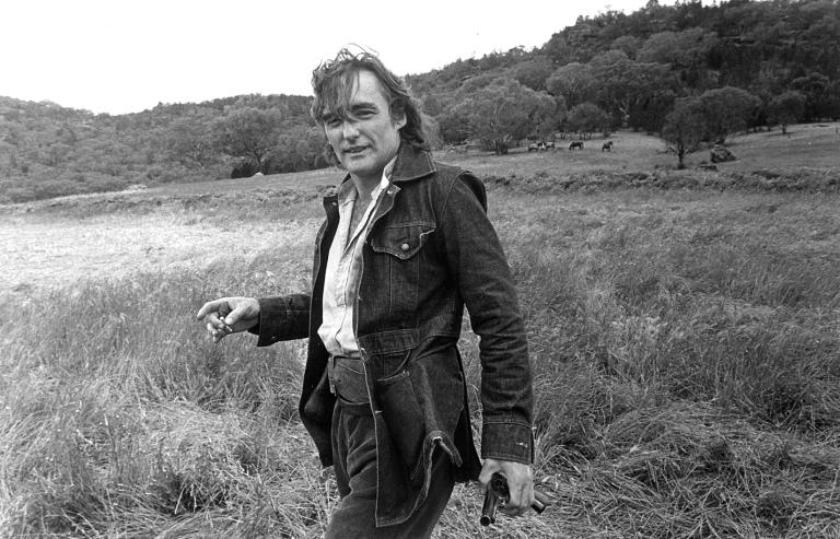 Dennis Hopper holding a cigarette and gun prop in costume and on location in Australia filming the movie Mad Dog Morgan