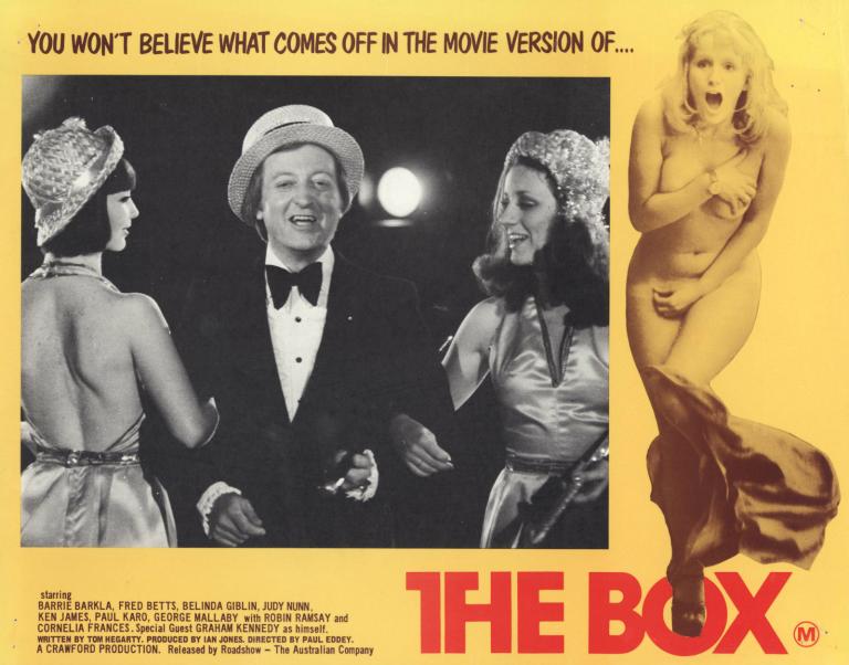 Lobby card for the feature film The Box with Graham Kennedy standing between two girls, naked woman on the side and text 'you won't believe what comes off in the movie version of... The Box'