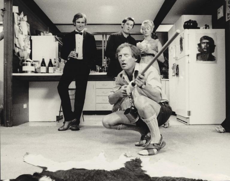 Mack (Graham Kennedy) crouching holding a broomstick with Don (John Hargreaves), Mal (Ray Barrett) and Jody (Veronica Lang) in background