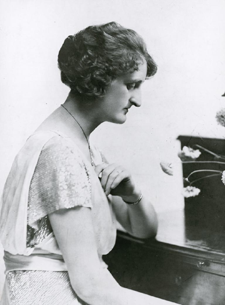 Una Bourne seated at a piano.