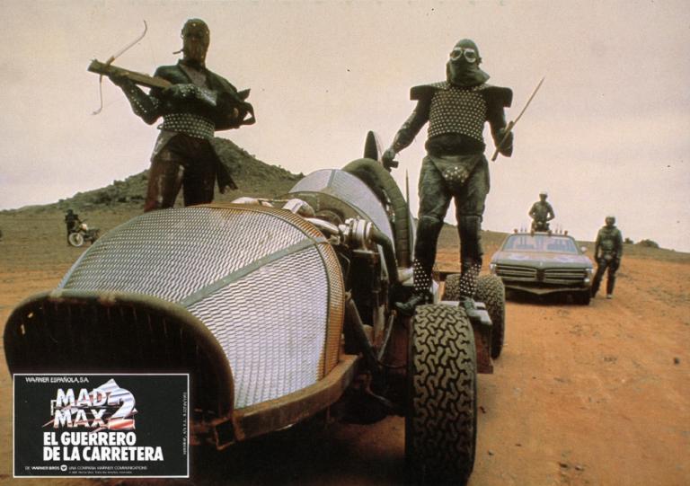 Lobby card showing two marauders holding weapons standing on a futuristic car.