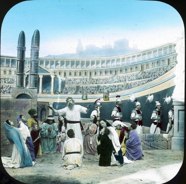 Roman guards leave the Colosseum as a man leads the Christians in prayer