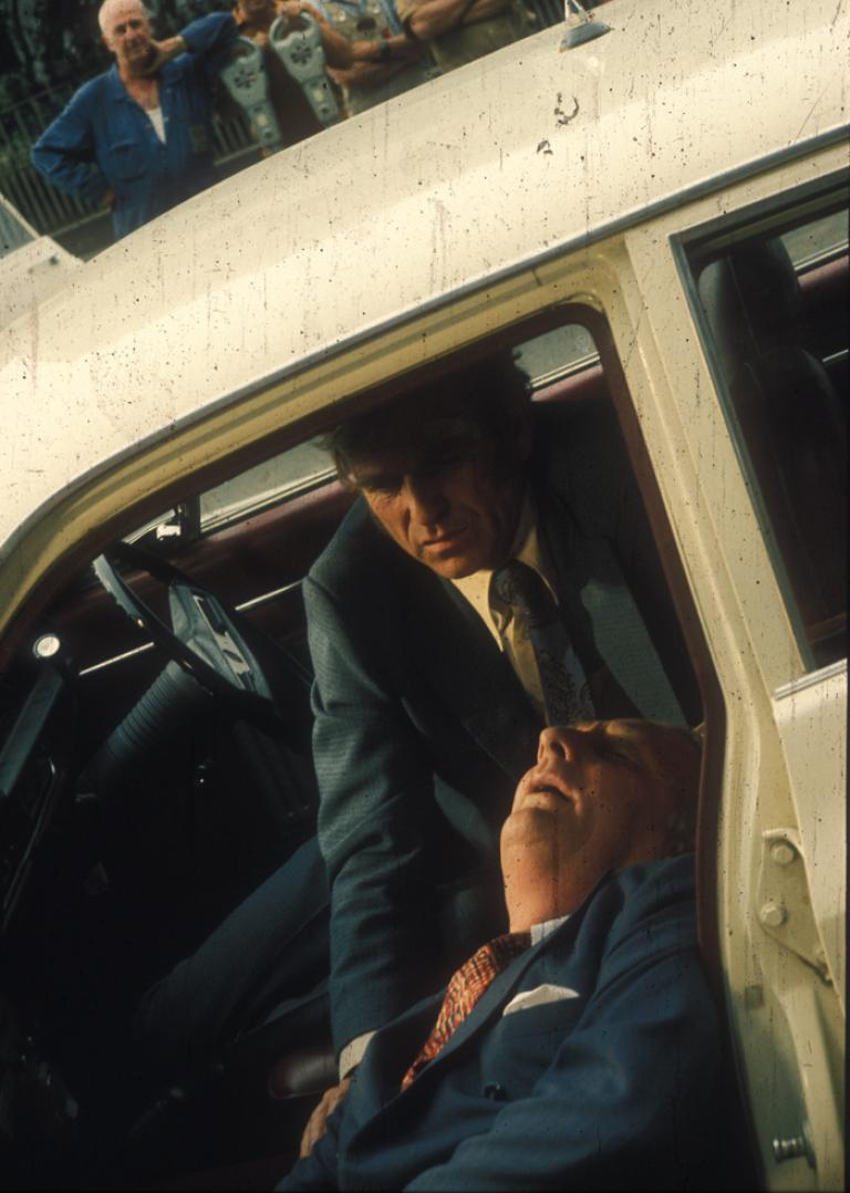 Production still from The Assassin episode of Homicide, Alwyn Kurts slumped in car with Leonard Teale over him