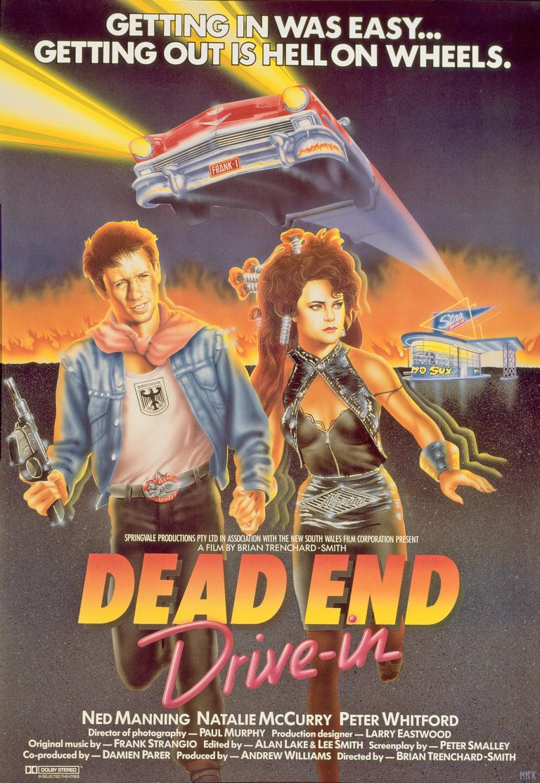 Poster art for the film Dead End Drive-In show a young man holding a machine gun and woman running away from a drive-in cinema. There is a red car with headlights on hovering above their heads. The film title and credits are at the bottom. 