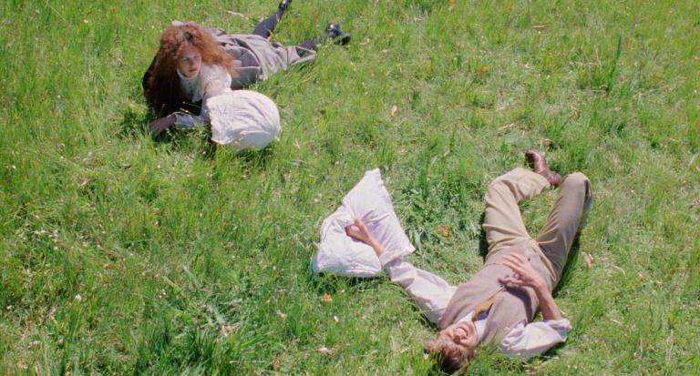 Judy Davis and Sam Neill lying in the grass in a still from My Brilliant Career
