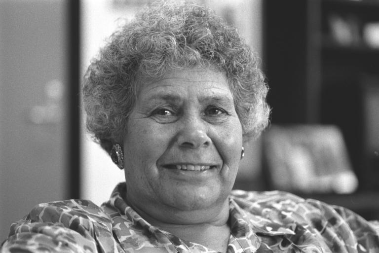 Head and shoulders portrait of Indigenous activist Lois O'Donoghue, smiling directly at camera.