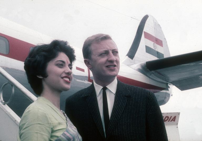 Graham Kennedy at the airport in India with an air hostess and a plane in the background