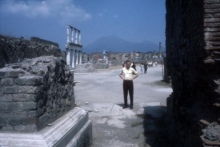 Graham Kennedy standing, hands on hips, exploring ancient ruins, Italy