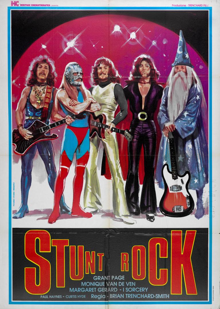 Poster art for film 'Stunt Rock'. Five men in various costumes standing in a row, looking like a 'glam' rock band. Some are dressed in leotards, one is dressed like a wizard and 3 are holding guitars.