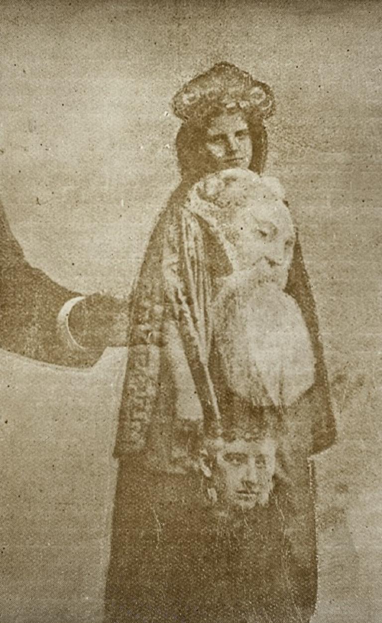 Sepia tone glass slide showing a female spirit with a man and boy superimposed over her.  An arm is reaching in from left side of image.
