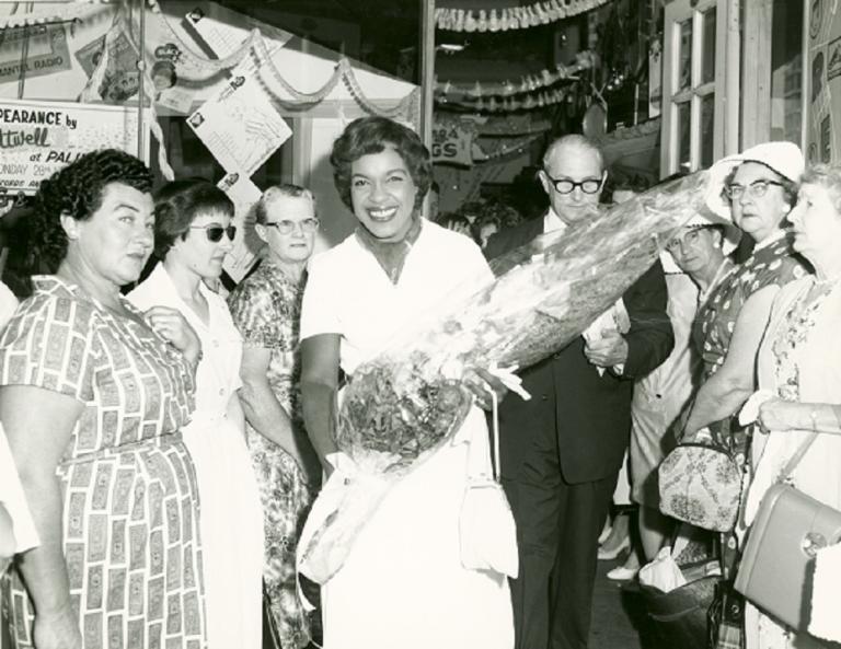 Winifred Atwell holds a large bouquet of flowers surrounded by fans