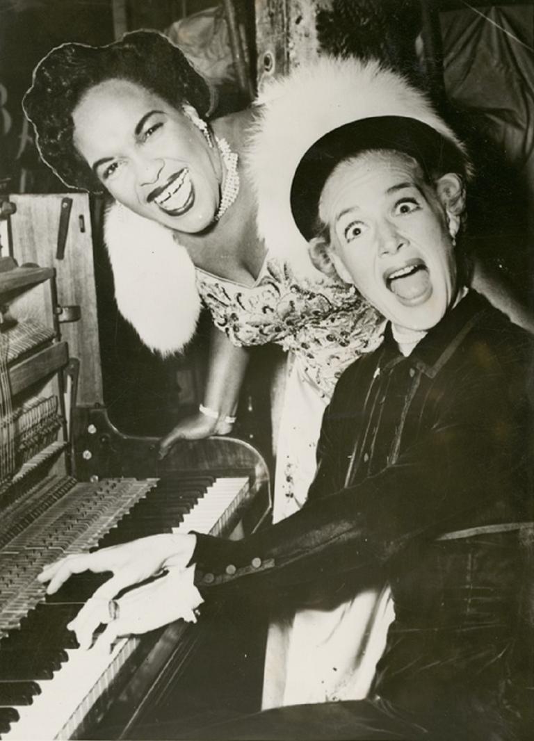 Actress Betty Hutton plays Winifred Atwell's piano and makes a crazy face while Atwell laughs