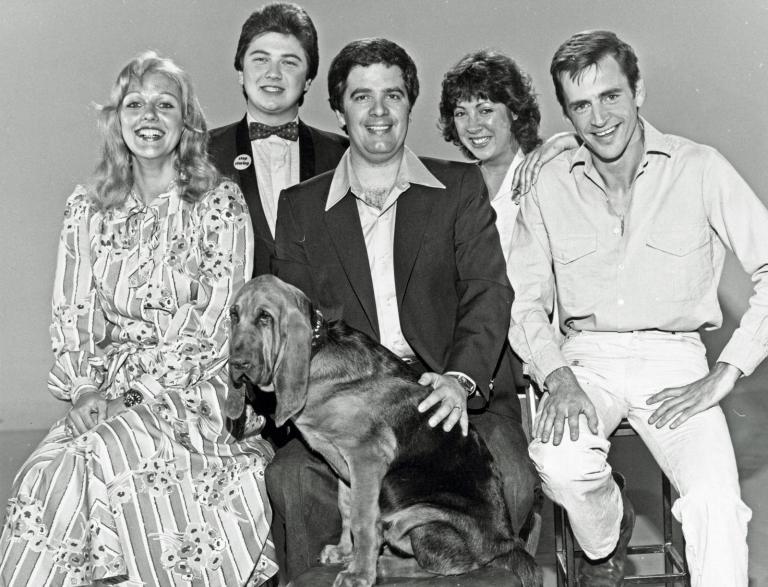 Publicity still for Simon Townsend's Wonder World! featuring the reporters and host. Pictured from left to right: Sandra Mauger, Jonathan Coleman, Simon Townsend, Angela Catterns, Adam Bowen, seated in front: Woodrow the bloodhound.