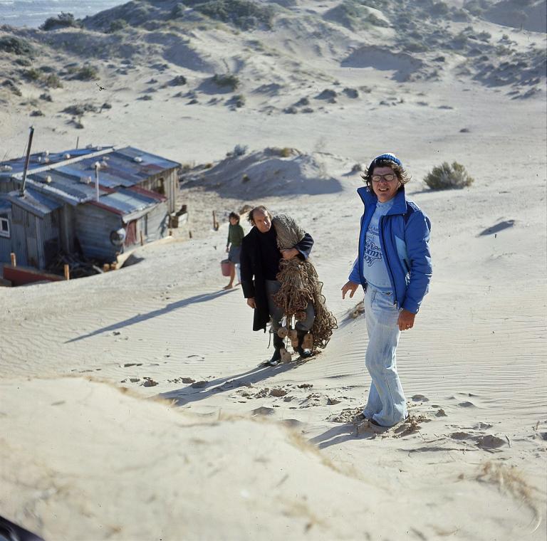 Director Henri Safran standing in the sand dunes with actor Peter Cummins (Hide-Away Tom) above the humpy set from Storm Boy