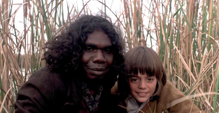 David Gulpilil as Fingerbone Bill and Greg Rowe as Storm Boy next to each other in the long grass