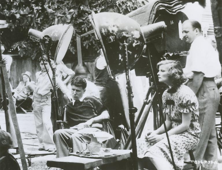 George Stevens and Katharine Hepburn seated on the set of Alice Adams, 1935.