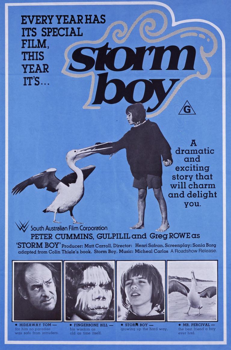 Australian poster for Storm Boy showing Greg Rowe with Mr Percival with his beak around Storm Boy's hand. Text reads 'every year has its special film. This year it's... Storm Boy'. Pictures of the main actors sit below.