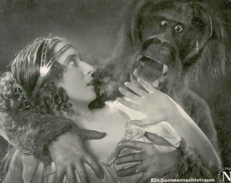Ruth Weyher is held and menaced by a man in an ape suit in a still from the German film A Midsummer Night's Dream, 1925.