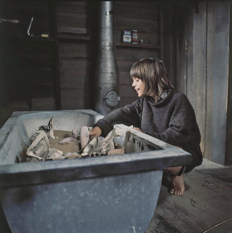 Greg Rowe as Storm Boy looking after baby pelicans who are sitting in an old bath tub in a scene from Storm Boy