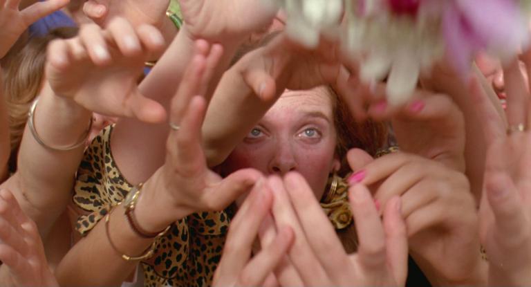 Muriel (Toni Collette) catching Tania's (Sophie Lee) bouquet through a sea of hands