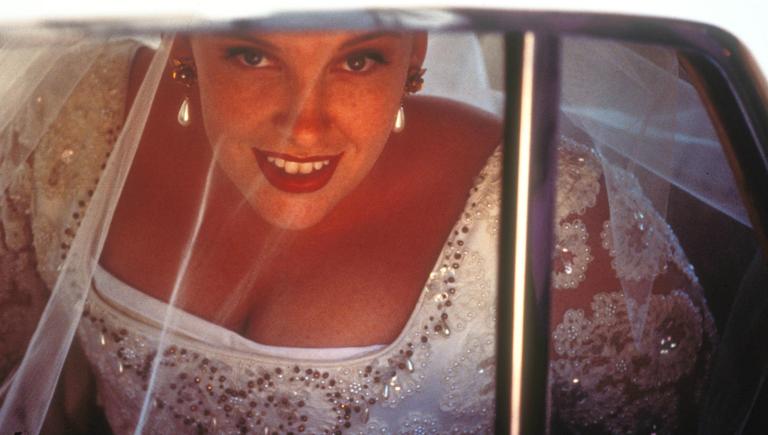 Muriel (Toni Collette) smiling out the car window as she arrives at her wedding