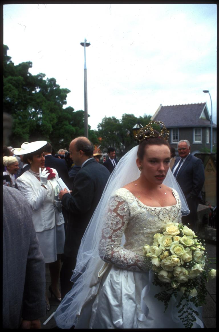 Muriel (Toni Collette) holding her bouquet outside the church
