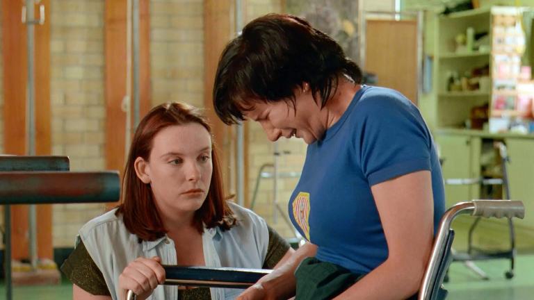 Muriel (Toni Collette) crouching beside a crying Rhonda (Rachel Griffiths) in her wheelchair