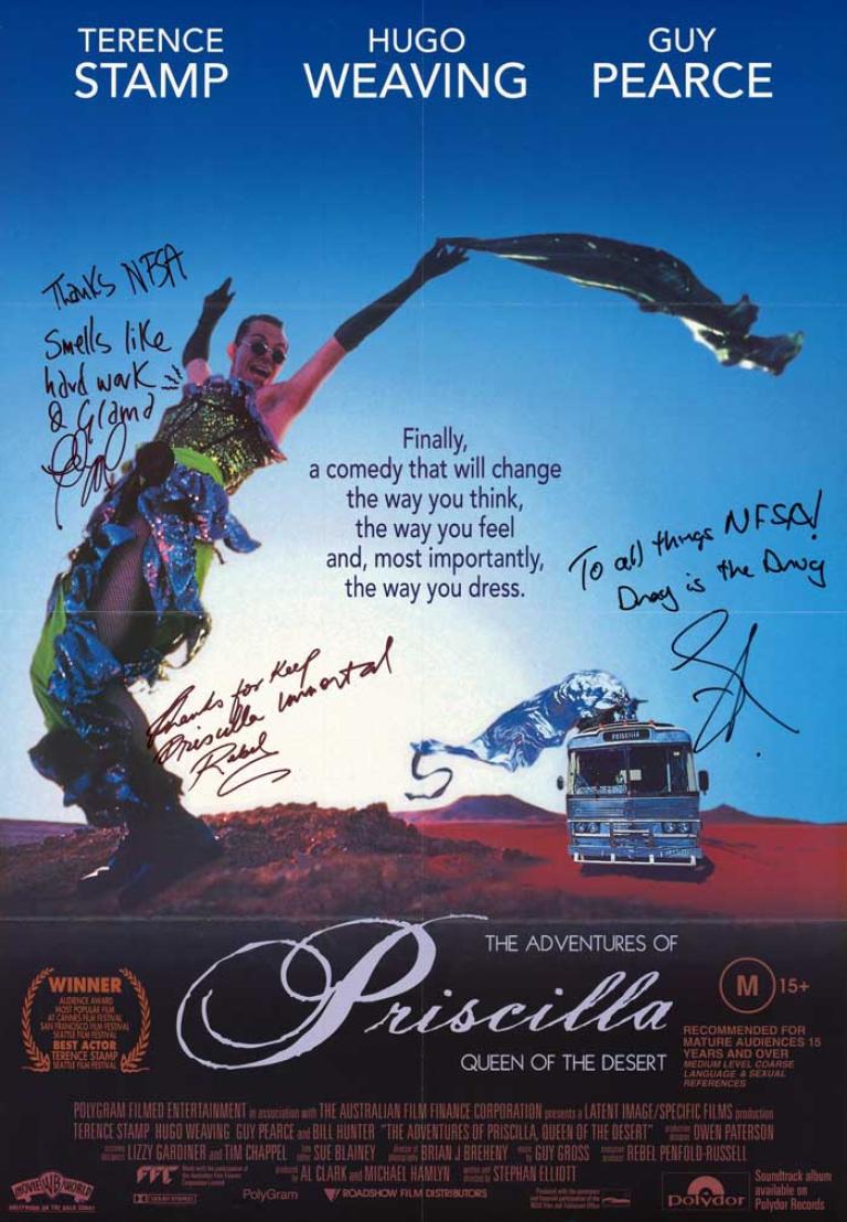 Poster from The Adventures of Priscilla, Queen of the Desert which is autographed by the crew. The poster features the iconic image of Hugo Weaving wearing the green sequin dress with the desert in the background