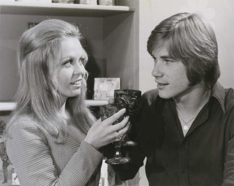 Jacki Weaver and Buddy England raise glasses in a 1970 episode of Australian detective show Homicide