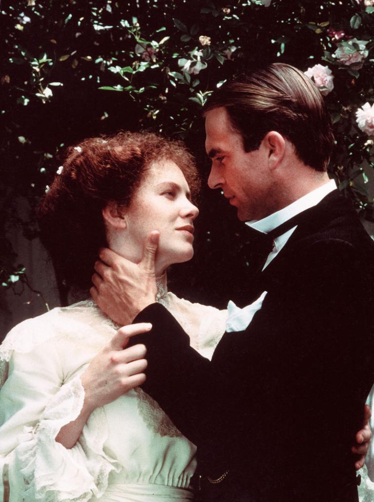 Judy Davis as Sybylla and Sam Neill as Harry embrace. He is touching her neck and she is touching his arm. They look at each other lovingly.