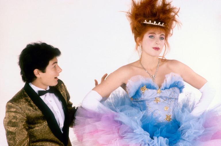 Publicity portrait featuring Ross O’Donovan as Angus and Jo Kennedy as Jackie Mullens. He wears a tuxedo and she wears a tutu and crown with spiked hair.