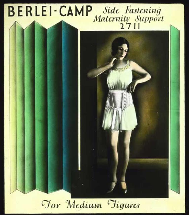A glass slide illustration of the Berlei-Camp side fastening maternity support 2711 for medium figures. A woman is wearing the garment. The glass slide is hand-coloured. 