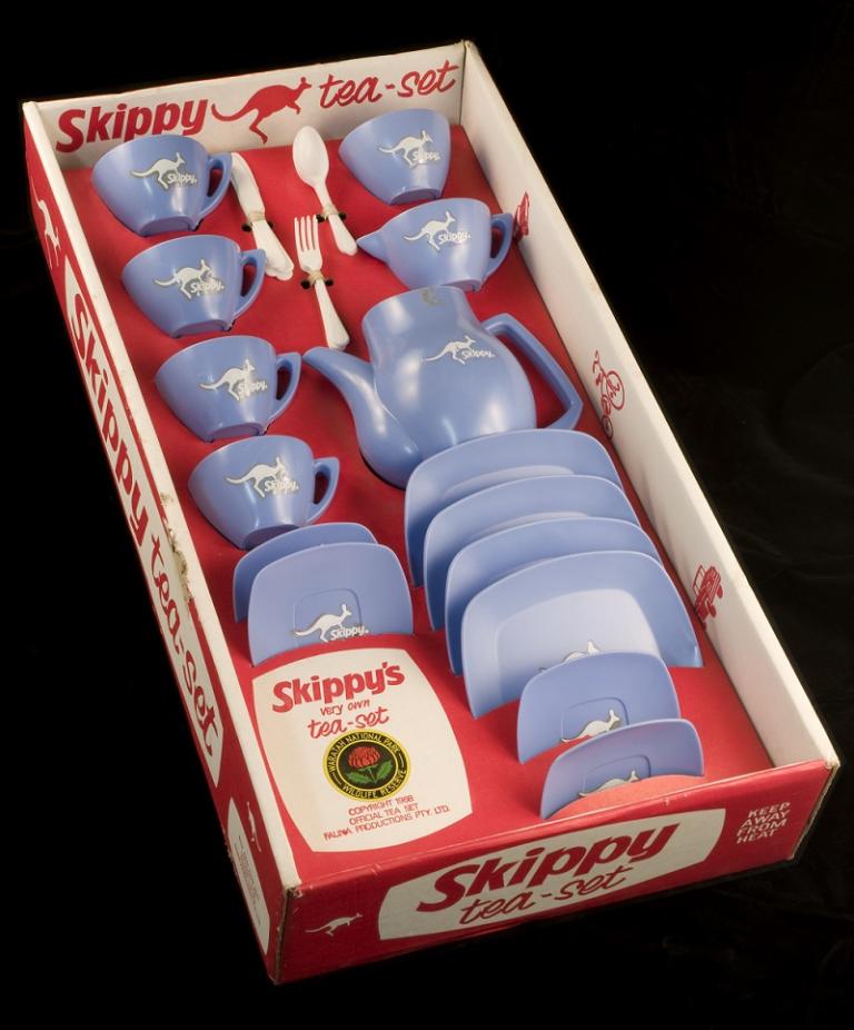 Blue plastic tea set with kangaroo motif in red cardboard box. 'Skippy Tea Set' logo on box.