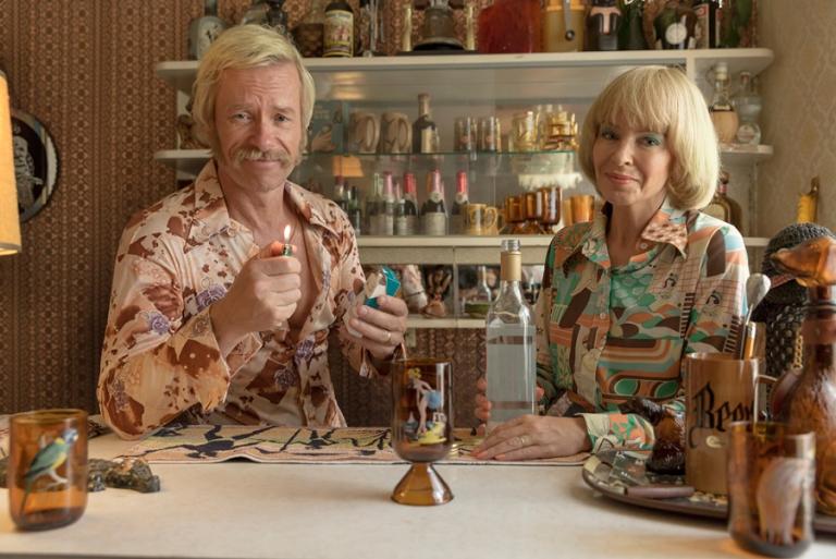 Kylie Minogue and Guy Pearce dressed in 1970s clothing in a production still from Swinging Safari.
