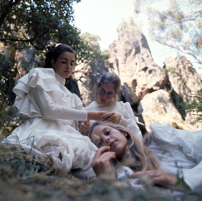 The College's senior girls in the grass at the base of the rock