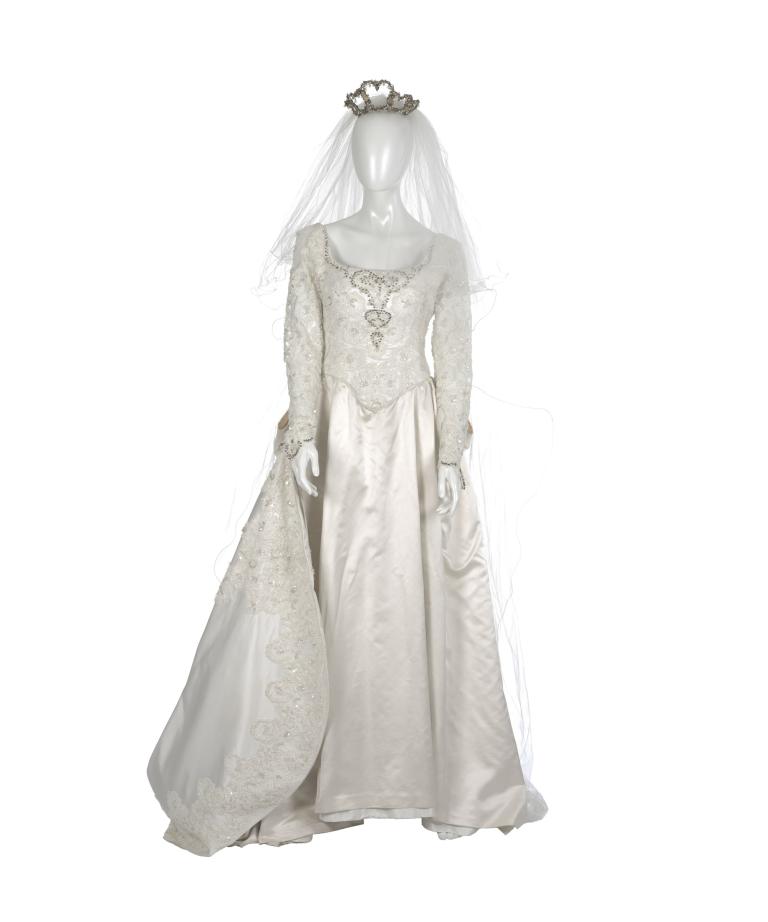 The wedding gown worn by Muriel (Toni Collette) features a low neckline, highly decorated bodice, ornate lace sleeves and a full skirt with a train in heavy ivory satin.