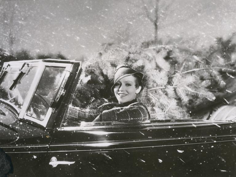 Hungarian actress Käthe von Nagy in a convertible car, with a Christmas tree in the back seat. 