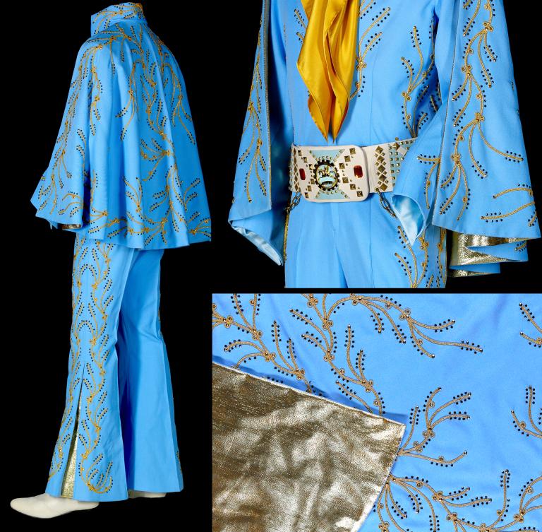 Film costume consisting of a blue jumpsuit and cape with gold embroidery and lining, with a rhinestone studded belt and yellow scarf.