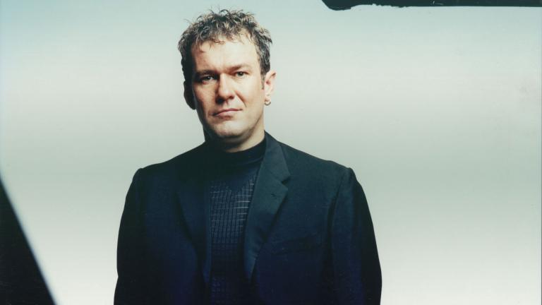 Jimmy Barnes wearing black suit and black shirt pictured from waist up looking directly at camera.