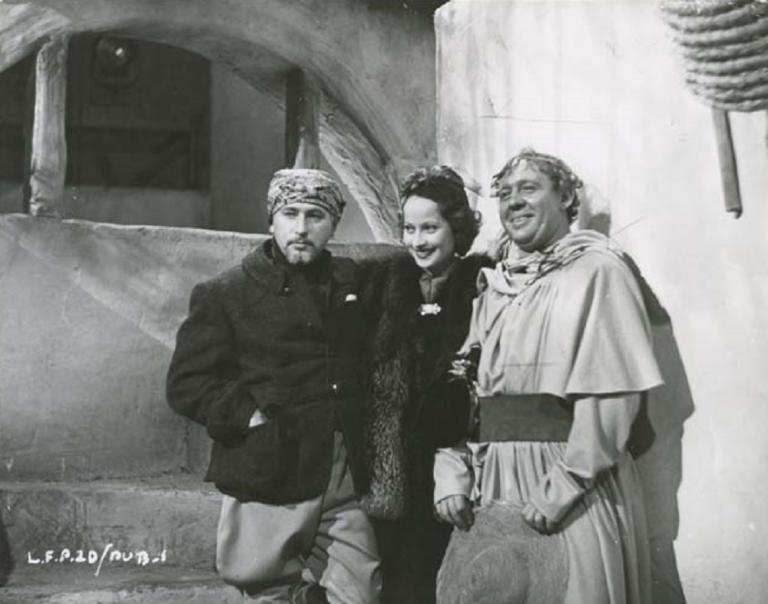 Merle Oberon stands between two men on the set of "I Claudius'.