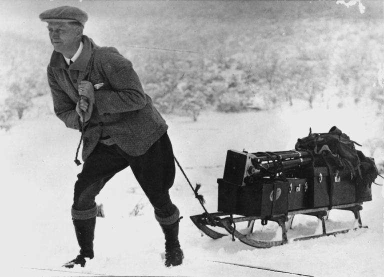 An unidentified member of the early Cinema and Photographic Branch pulls a sledge with equipment in the snow.
