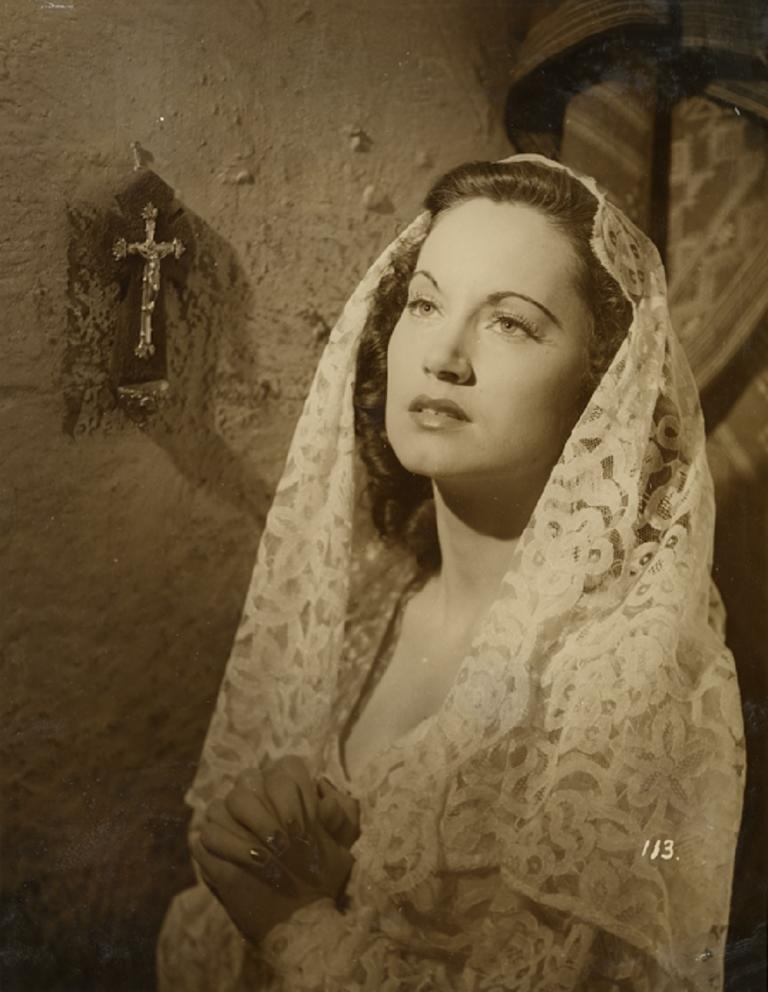 Betty Bryant wearing a shawl next to a crucifix in a scene from Forty Thousand Horsemen.