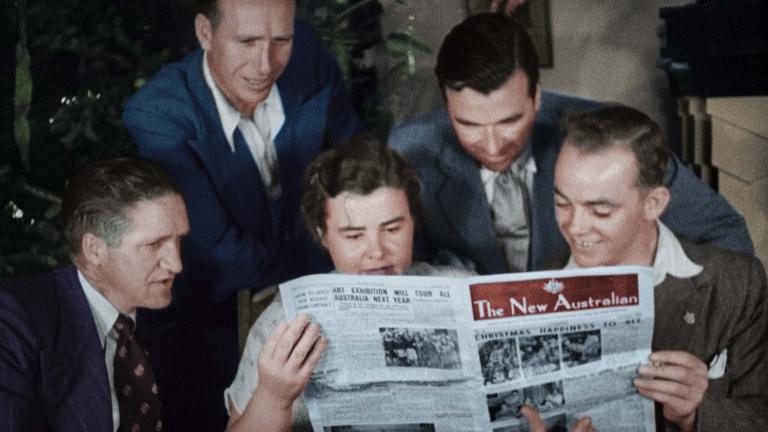 A group of five adults read a newspaper entitled 'The New Australian' in the late 1940s